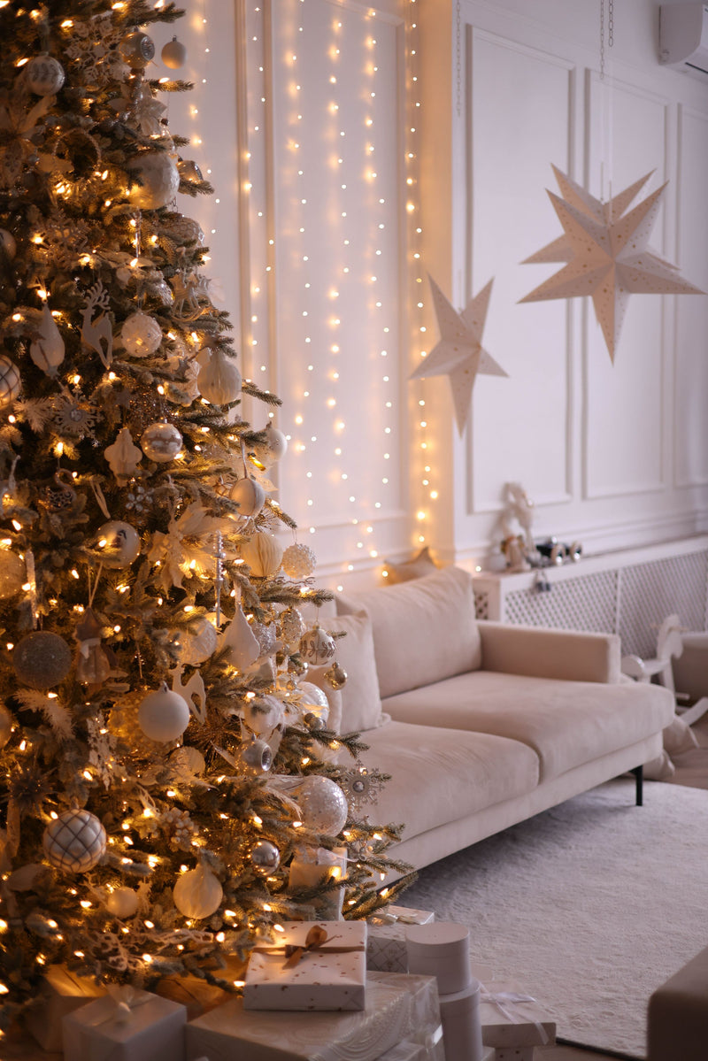 Decorated Christmas tree with lights and gifts in a cozy living room