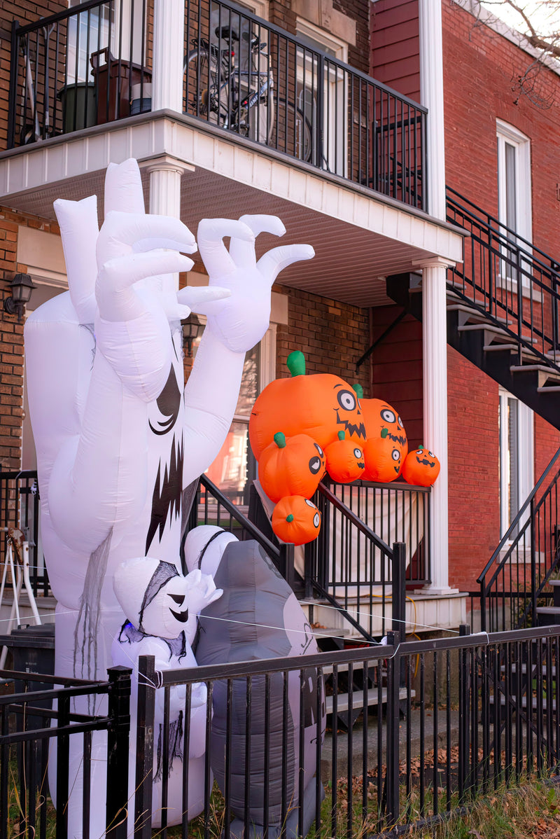 Lighted Halloween inflatables on a decorated front porch