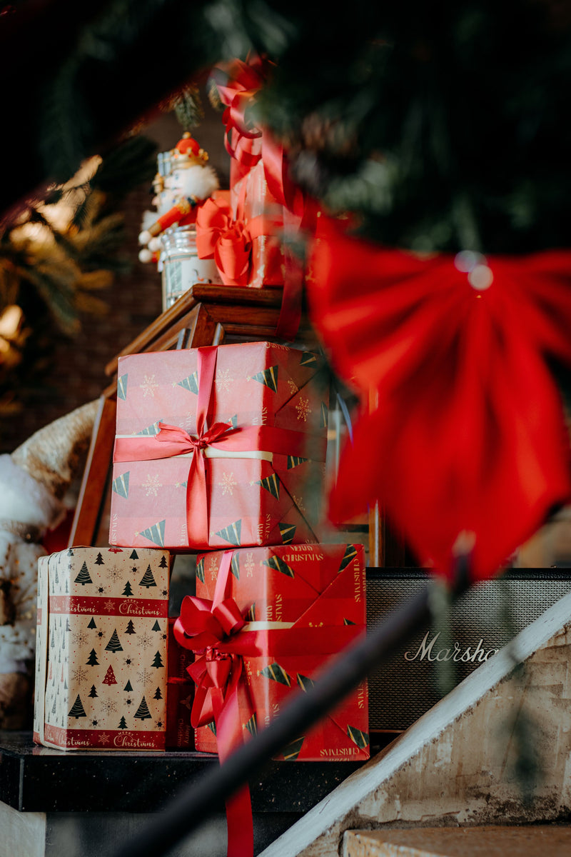 Stack of Christmas gifts wrapped with red ribbons