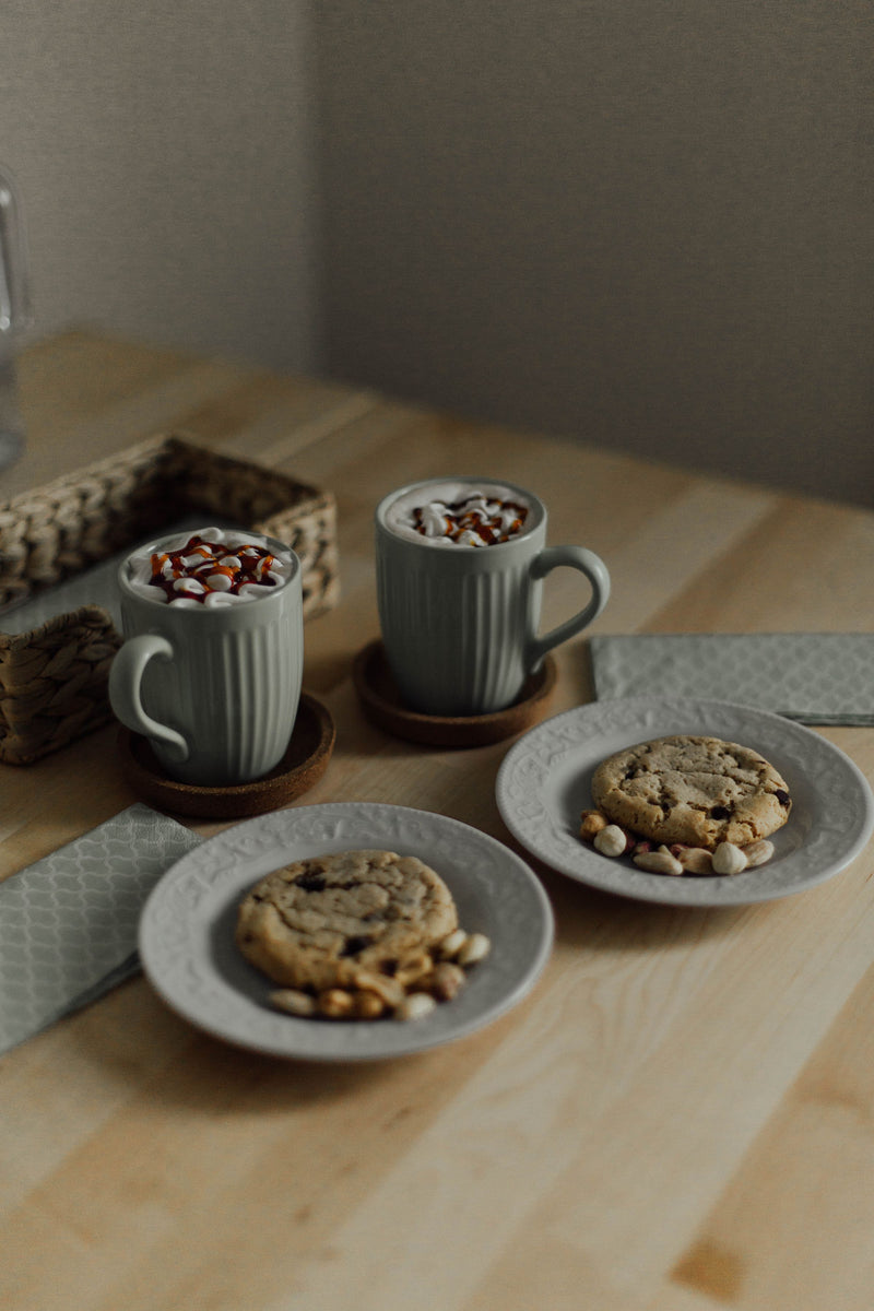 Mugs of hot chocolate with cookies on a wooden table