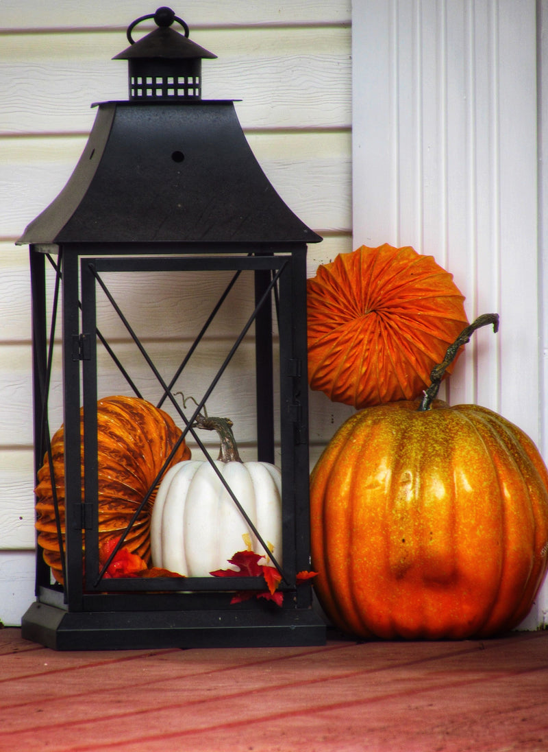 Pumpkins and a lantern on an autumn porch