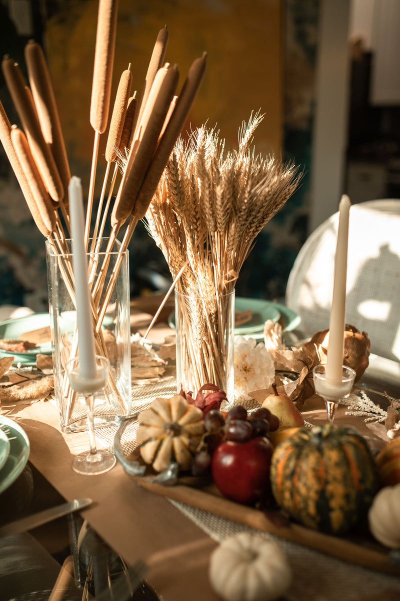 Thanksgiving table setting with candles, gourds and wheat